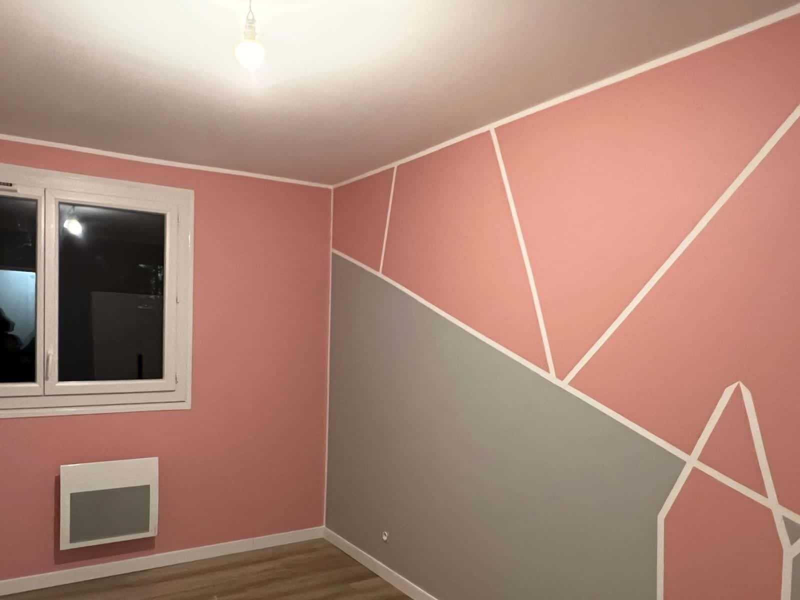 Chambre aux murs roses et gris avec motifs géométriques peints