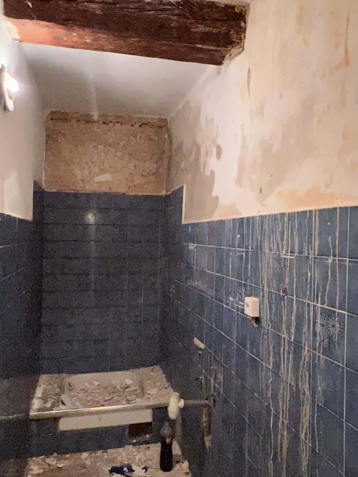 Salle d’eau en travaux, murs dégradés au-dessus du carrelage