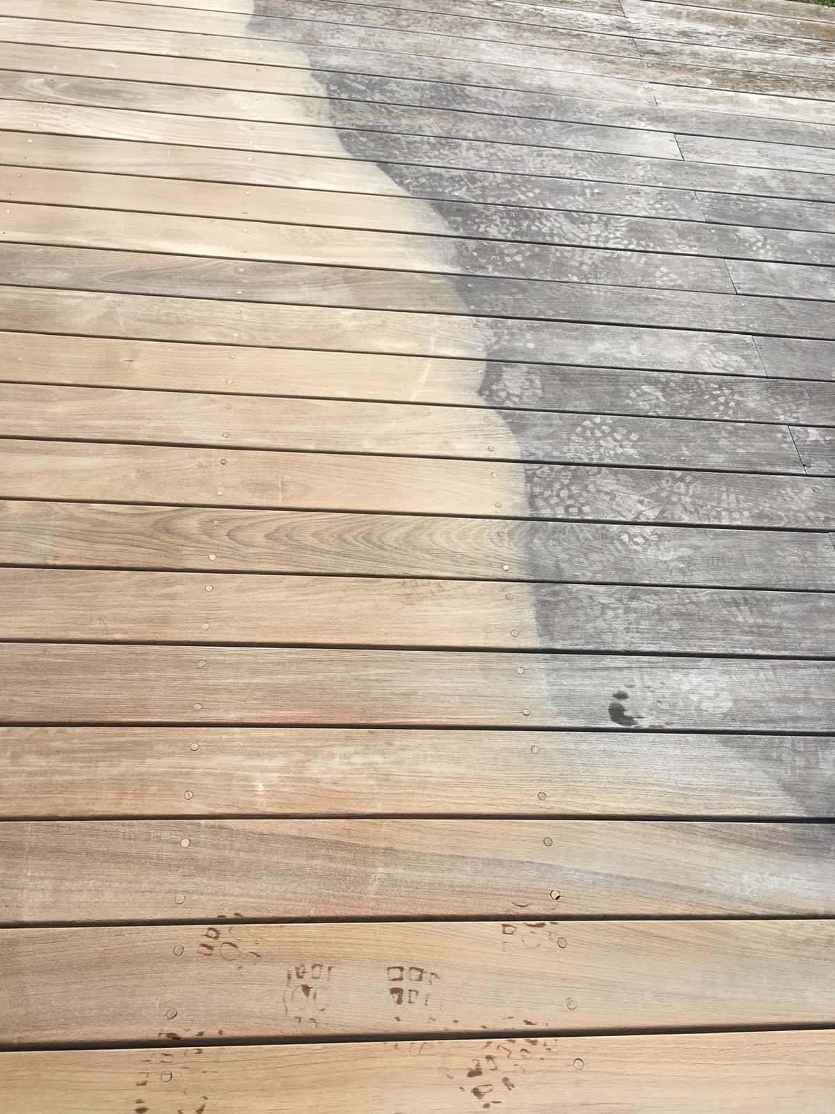 Terrasse en bois en cours de nettoyage, avec partie claire et partie grisée