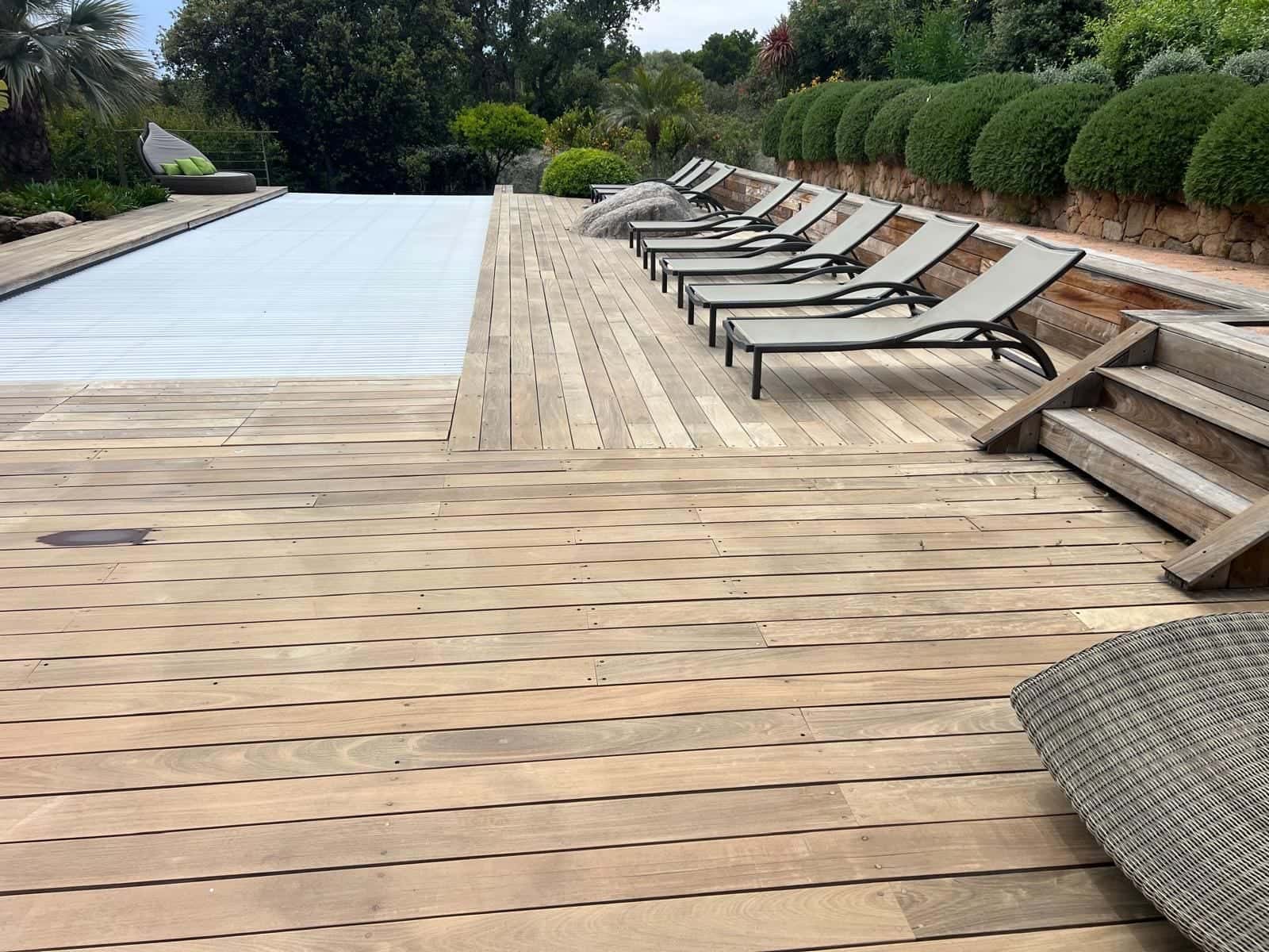 Terrasse en bois entretenue autour d'une piscine