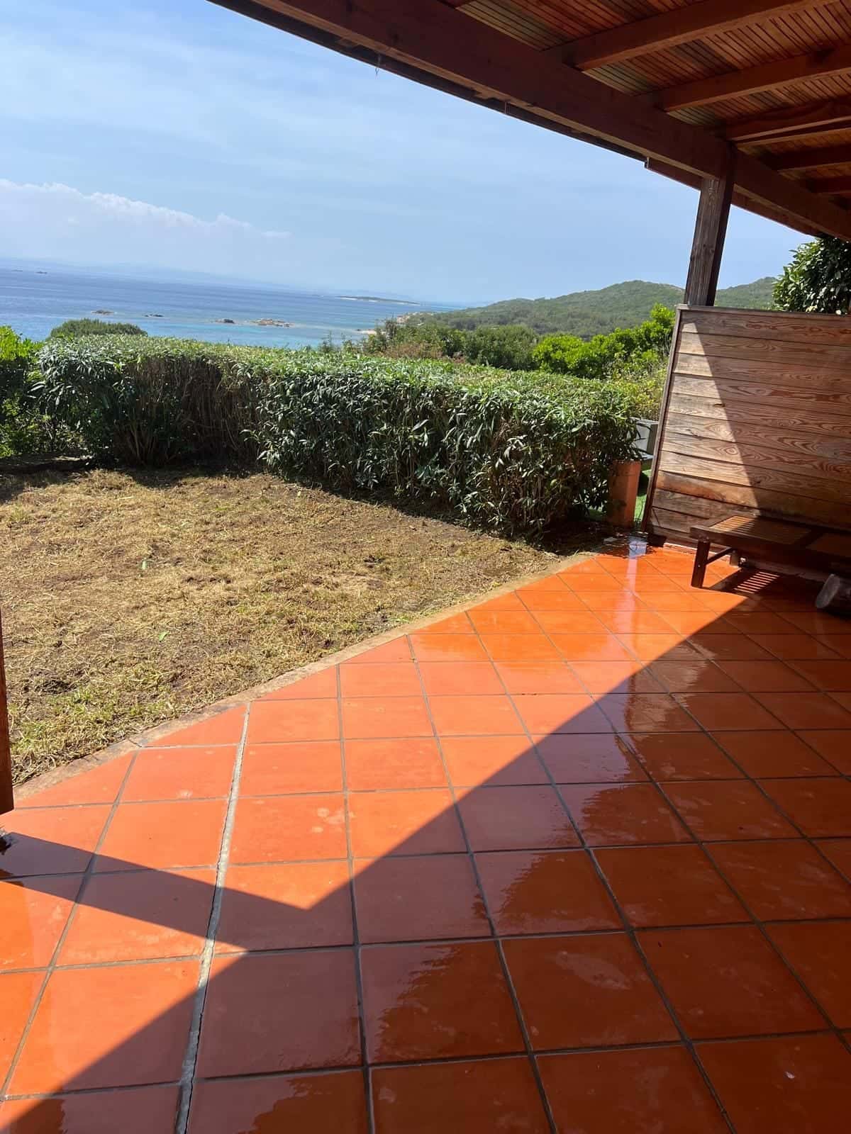 Terrasse en tomettes nettoyée sous un toit avec vue sur la mer