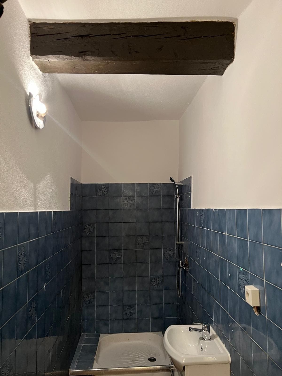 La même salle d’eau avec murs repeints et douche installée