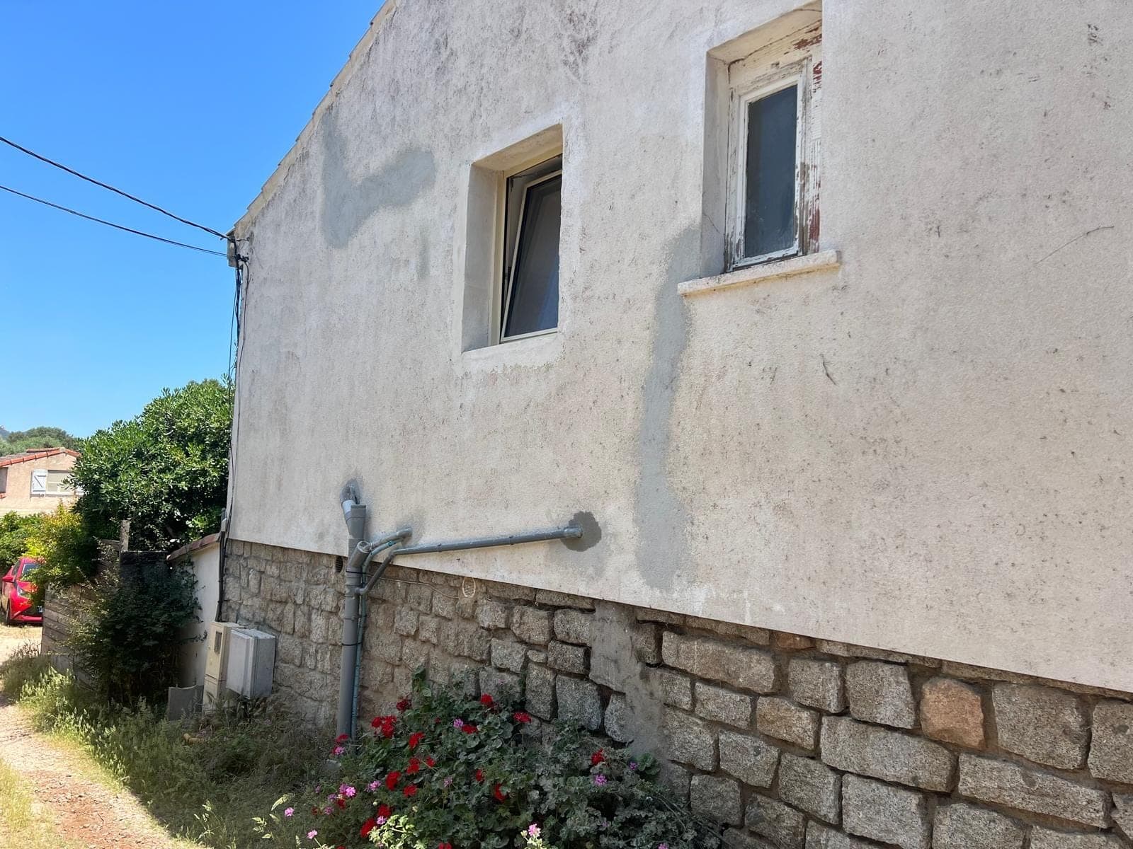 Façade tachée au-dessus d’un soubassement en pierre