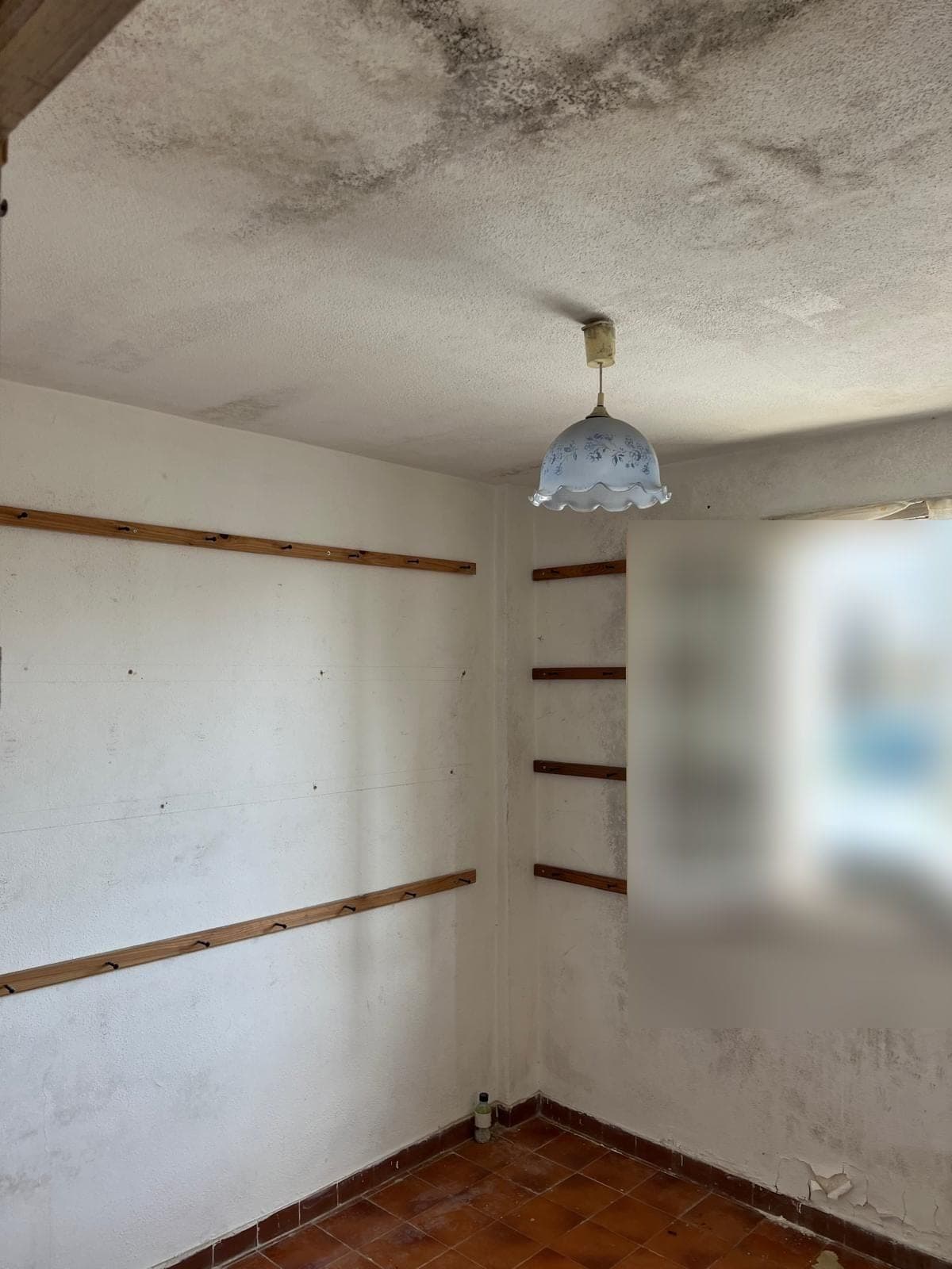 Petite chambre aux murs et plafond tachés