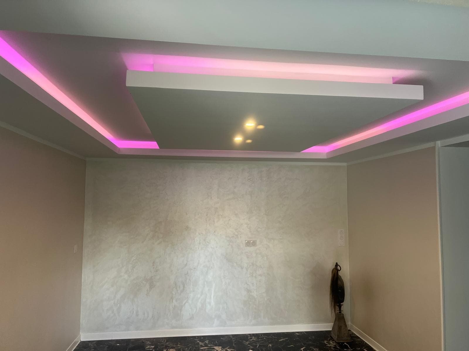 Pièce avec faux plafond éclairé et murs à effet décoratif