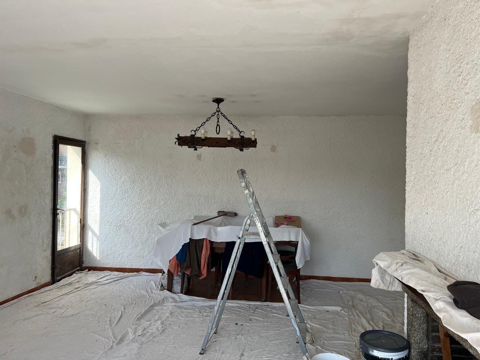 Salle à manger aux murs tachés, protégée pour les travaux