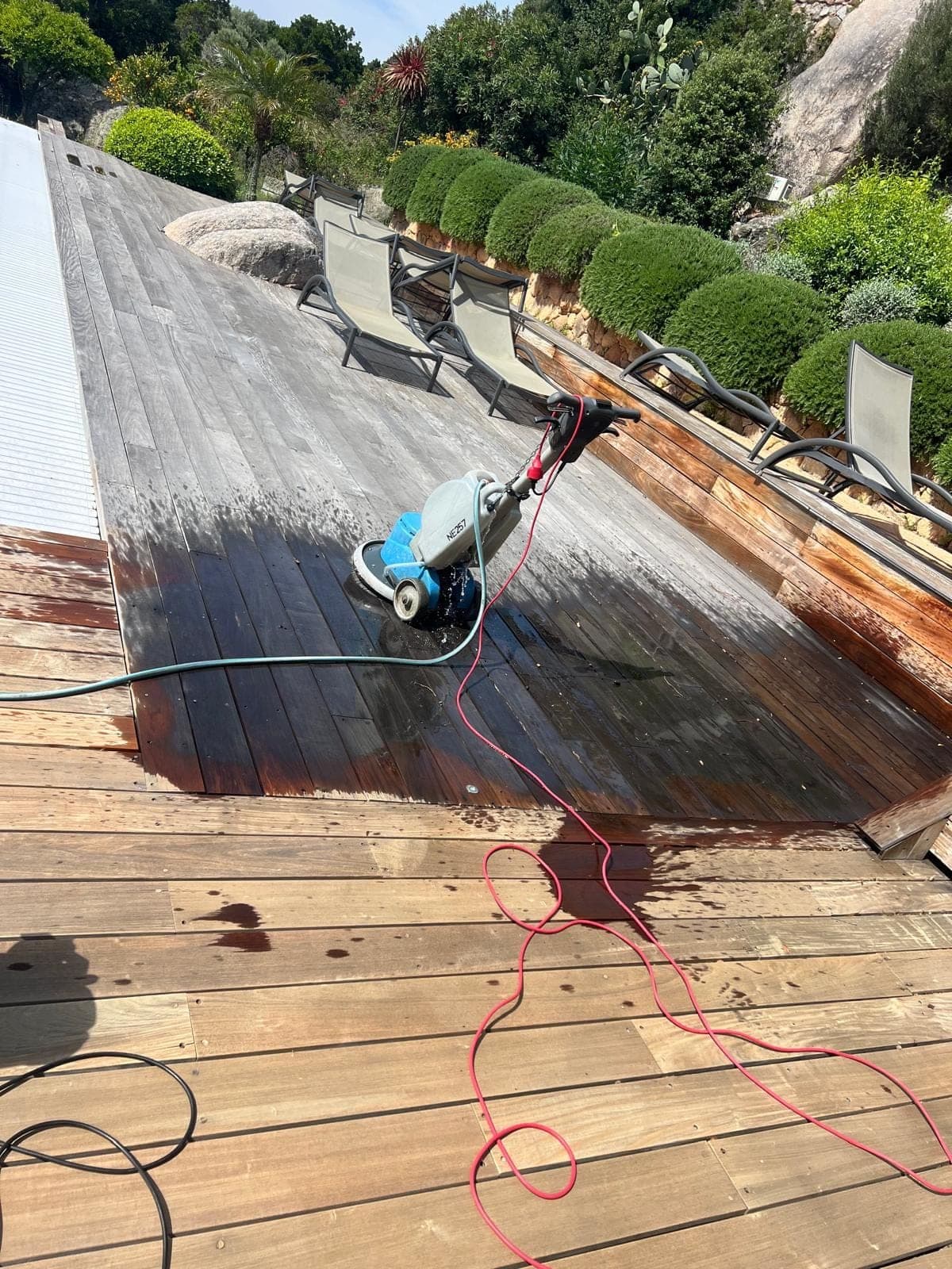 Terrasse en bois pendant le nettoyage, partie traitée et partie grisée