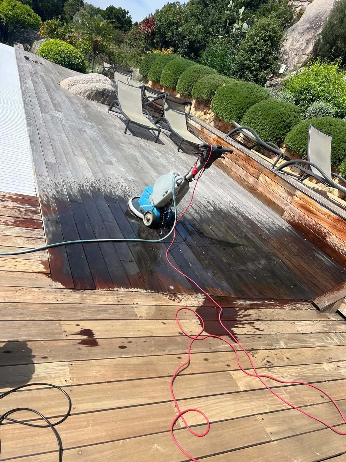 Terrasse en bois pendant le nettoyage, partie traitée et partie grisée